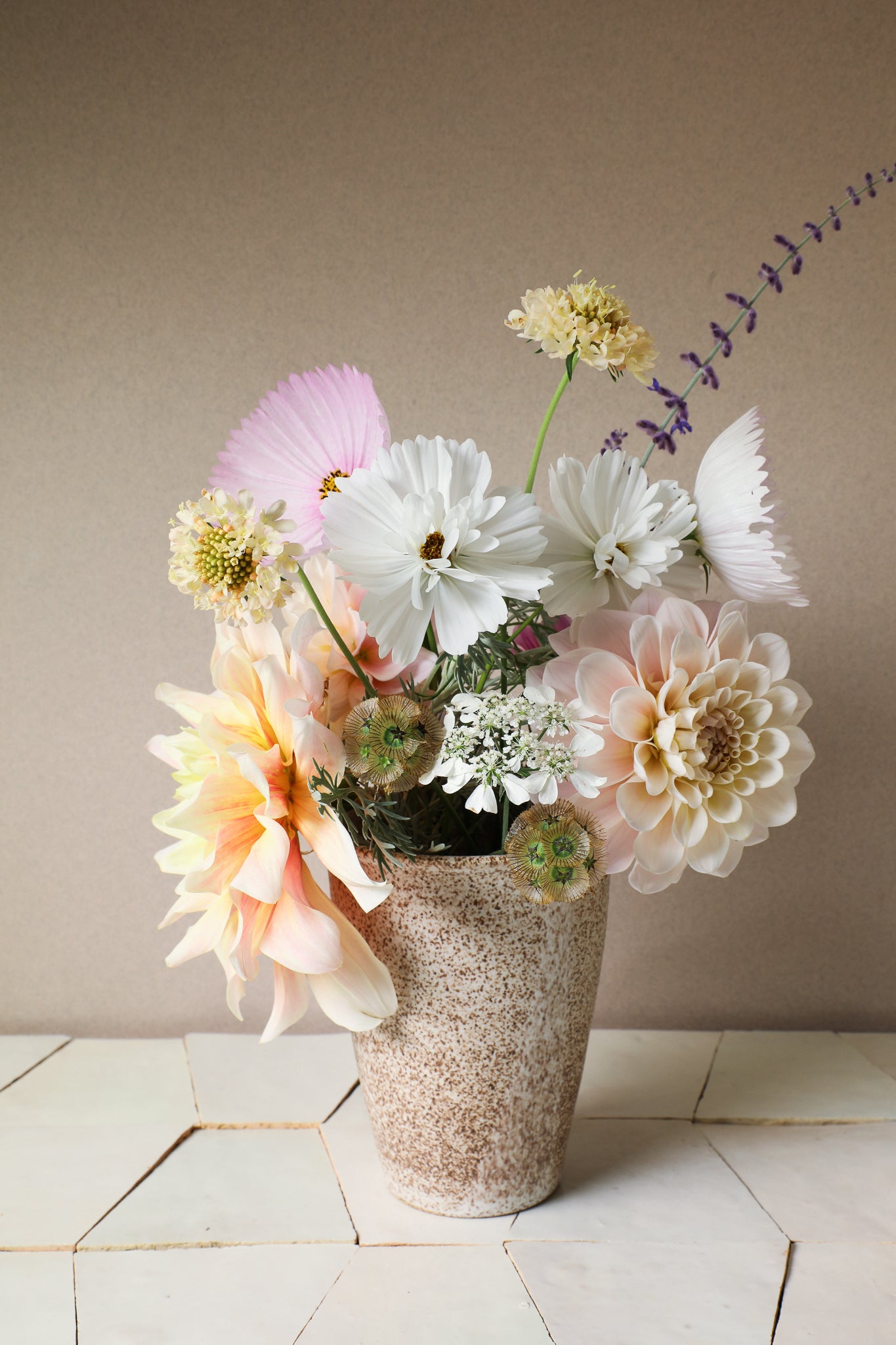 Speckled vase holding a collection of dahlia & cosmos flowers
